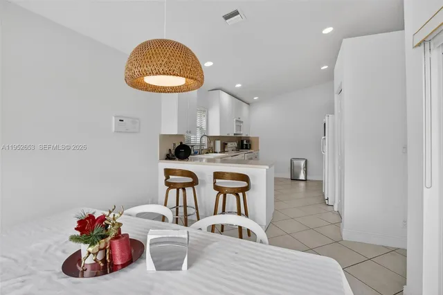 a kitchen with stainless steel appliances kitchen island granite countertop a sink and a white cabinets