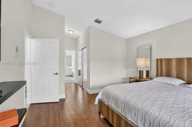a bedroom with a bed and wooden floor