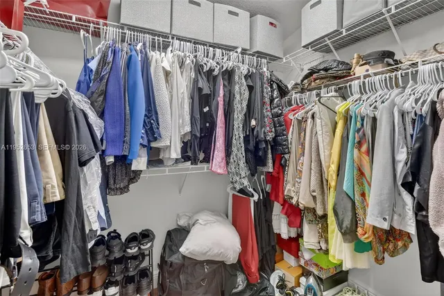 a view of walk in closet with clothes