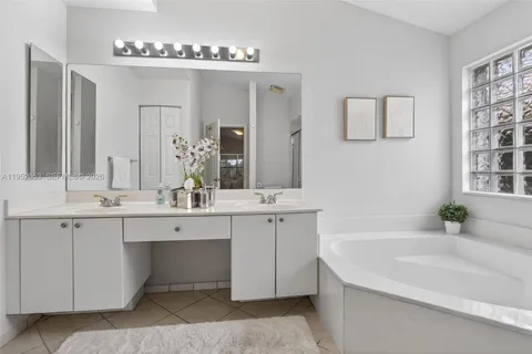 a bathroom with a tub sink and mirror