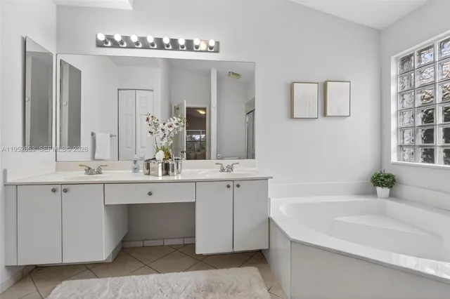 a bathroom with a tub sink and mirror