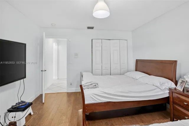 a bedroom with a bed and a flat screen tv