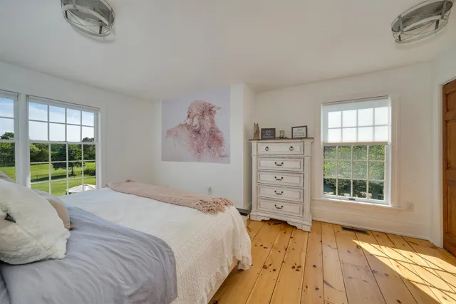 a bedroom with a bed and a large window