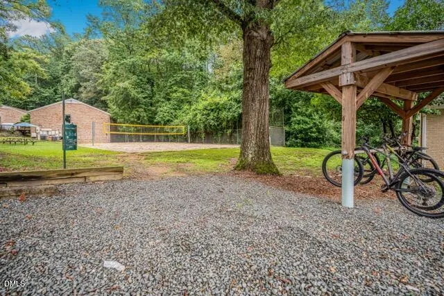 a view of a wooden house with a yard and furniture