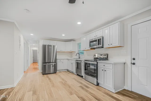 a kitchen with stainless steel appliances granite countertop a refrigerator and a stove top oven