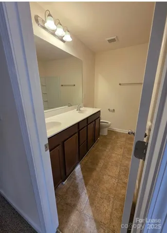 a bathroom with a sink and mirror with bathtub