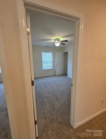 a view of a livingroom with a ceiling fan and window