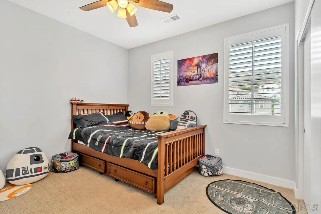 8869 Trailridge Avenue Santee, CA 92071 - Photo 23 of 48 a bedroom with a bed and a chandelier