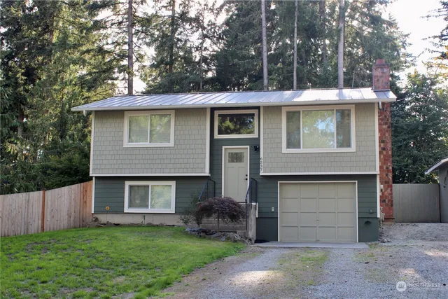 a front view of a house with a garden and garage