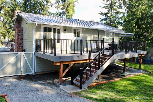 a view of a house with backyard wooden deck and sitting area