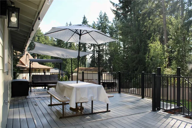 a view of a patio with table and chairs under an umbrella with wooden floor