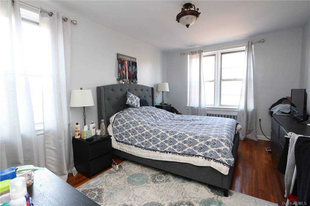 a bedroom with a bed and a dresser next to a window