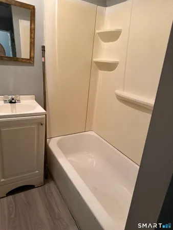 a bathroom with a tub sink and vanity