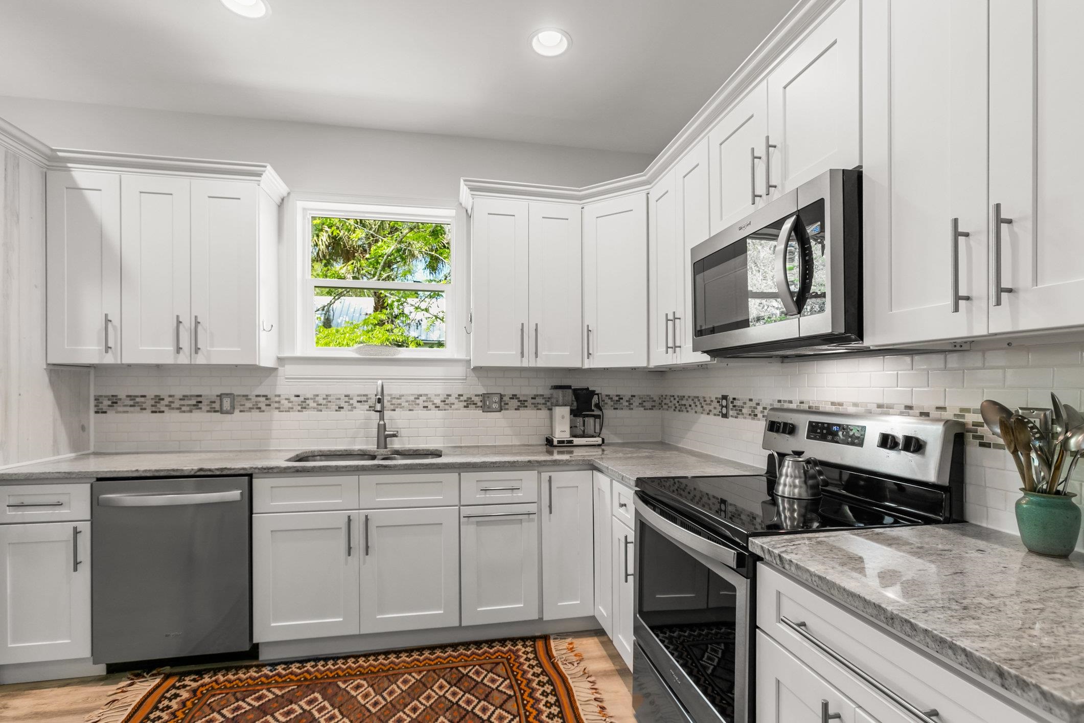 249 Riberia Street St. Augustine, FL 32084 - Photo 12 of 45 a kitchen with stainless steel appliances granite countertop white cabinets granite counter tops and a window