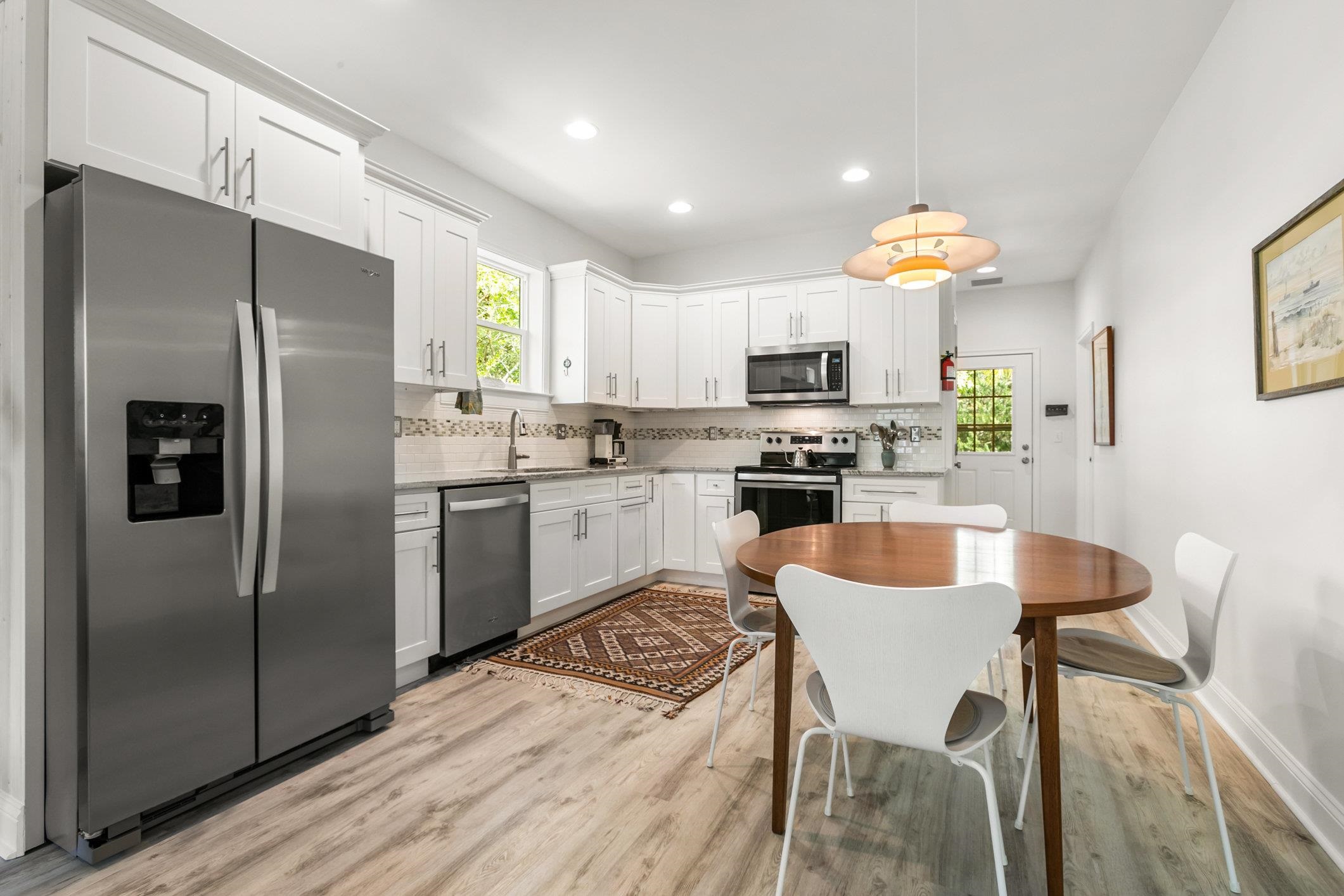 249 Riberia Street St. Augustine, FL 32084 - Photo 7 of 45 a kitchen with stainless steel appliances a refrigerator a stove a sink a dining table and chairs