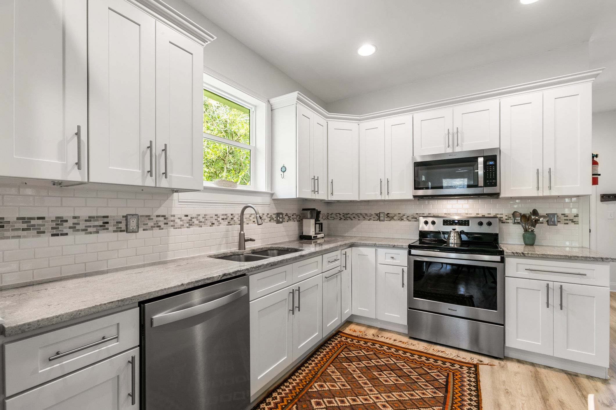 249 Riberia Street St. Augustine, FL 32084 - Photo 9 of 45 a kitchen with stainless steel appliances granite countertop white cabinets a sink and a stove
