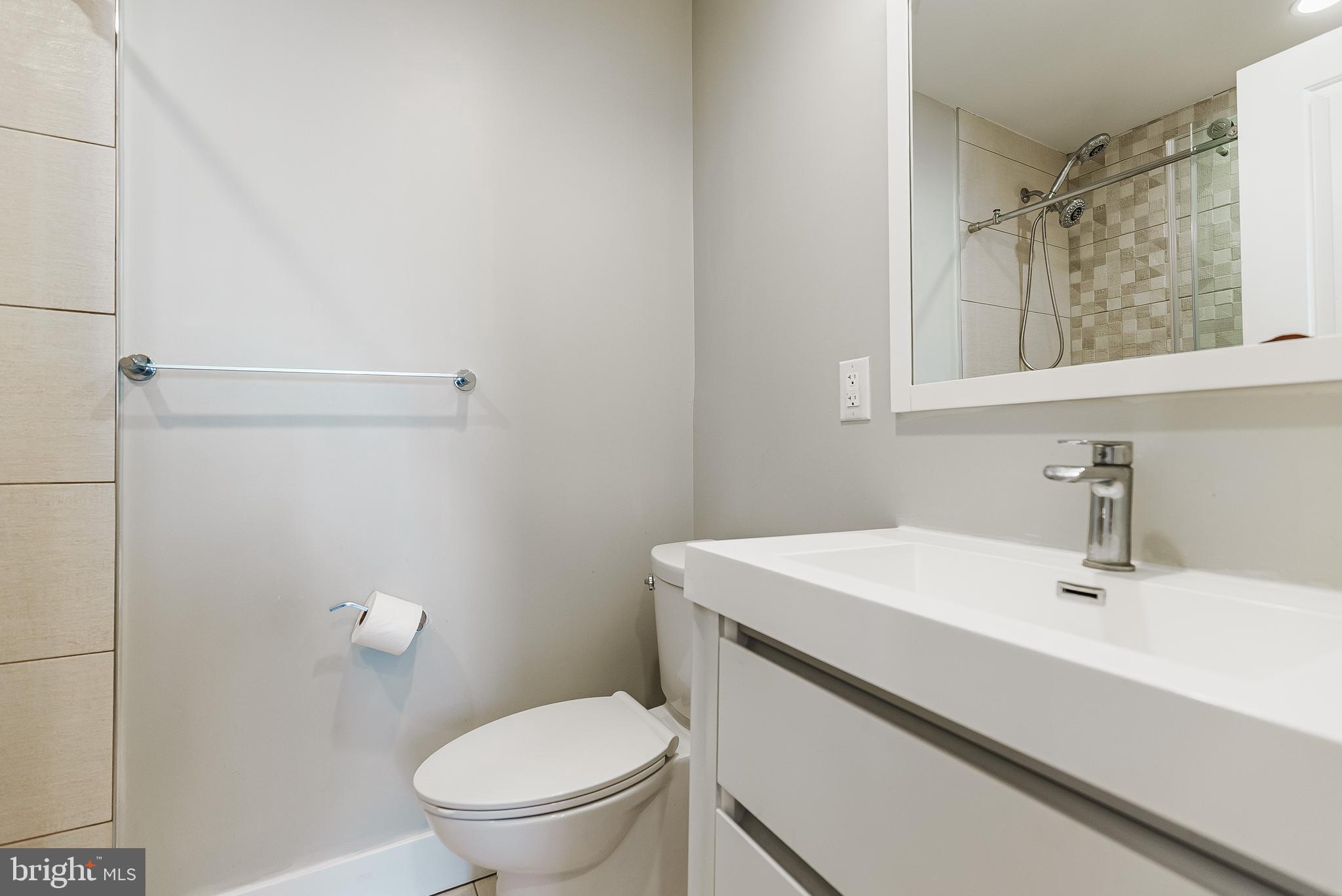 1331 South Dover Street Philadelphia, PA 19146 - Photo 17 of 24 a bathroom with a sink a toilet and a mirror