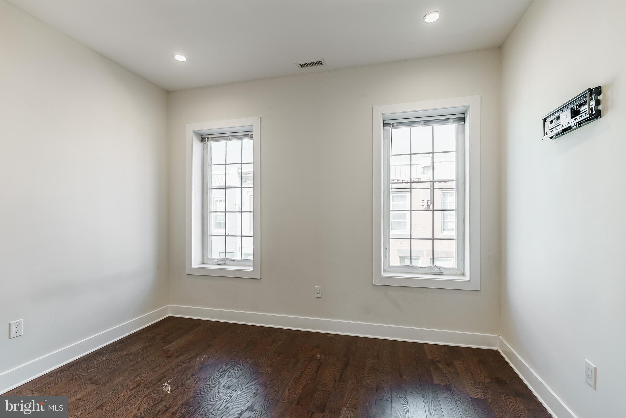 1331 South Dover Street Philadelphia, PA 19146 - Photo 19 of 24 an empty room with wooden floor and windows
