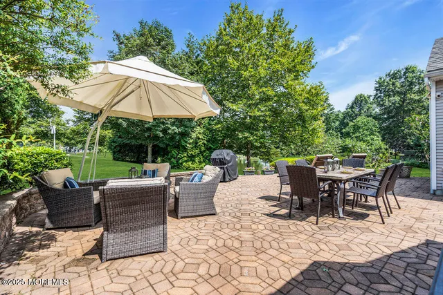 a view of a patio with a dining table and chairs under an umbrella