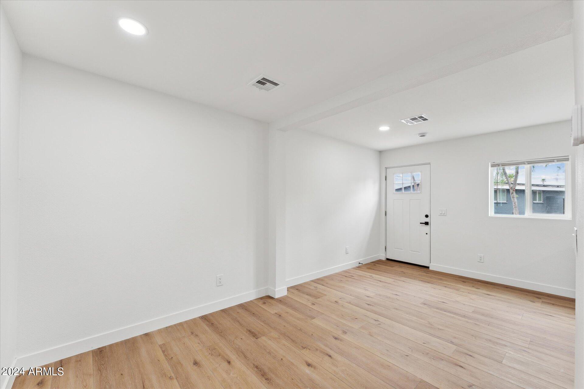 1548 North Upland Circle, Unit C Mesa, AZ 85201 - Photo 11 of 21 a view of an empty room with wooden floor and a window