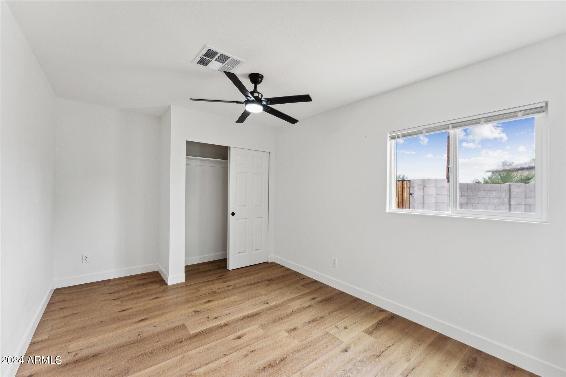1548 North Upland Circle, Unit C Mesa, AZ 85201 - Photo 12 of 21 a view of an empty room with wooden floor and a window