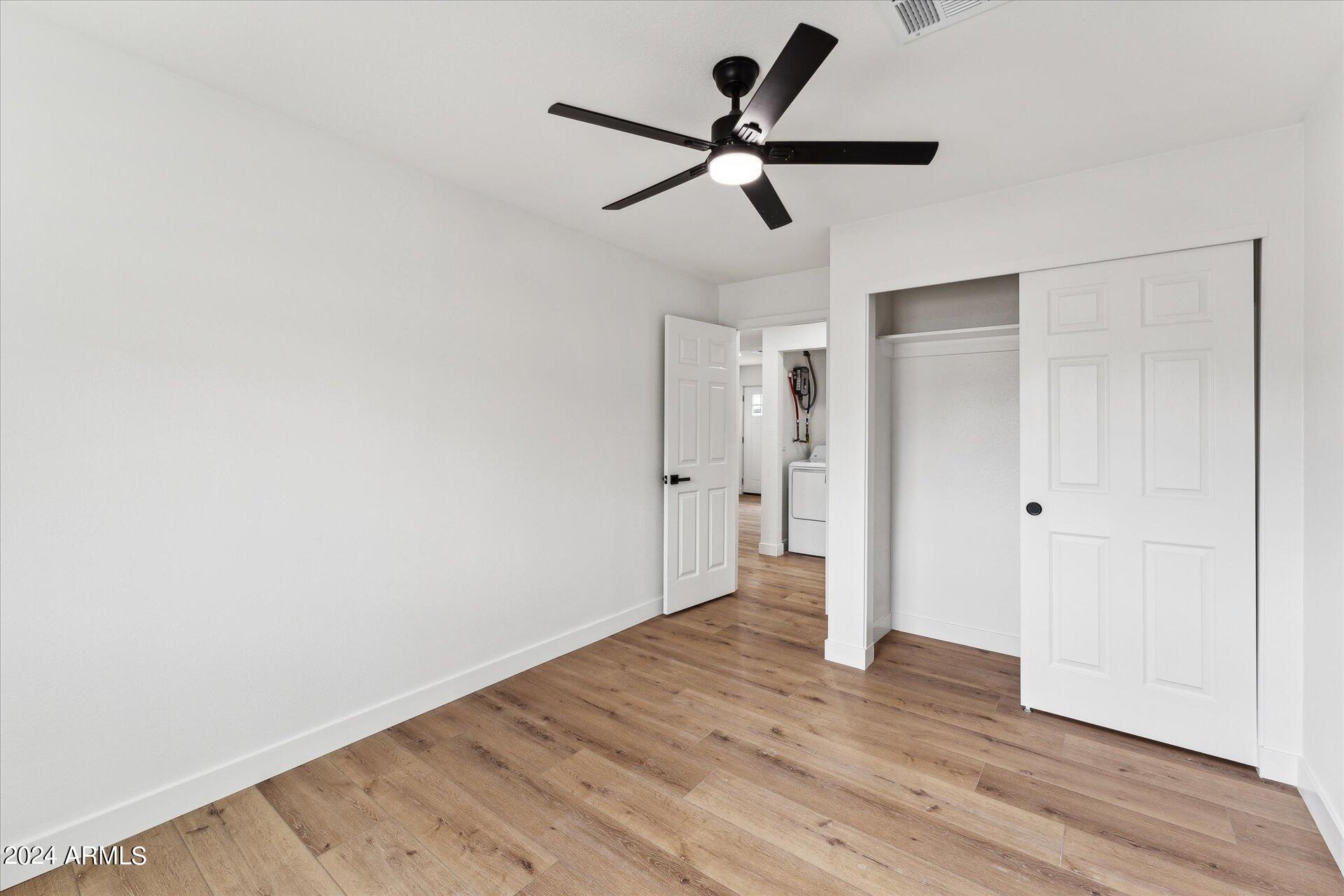 1548 North Upland Circle, Unit C Mesa, AZ 85201 - Photo 15 of 21 an empty room to hallway with wooden floor wooden door and a ceiling fan