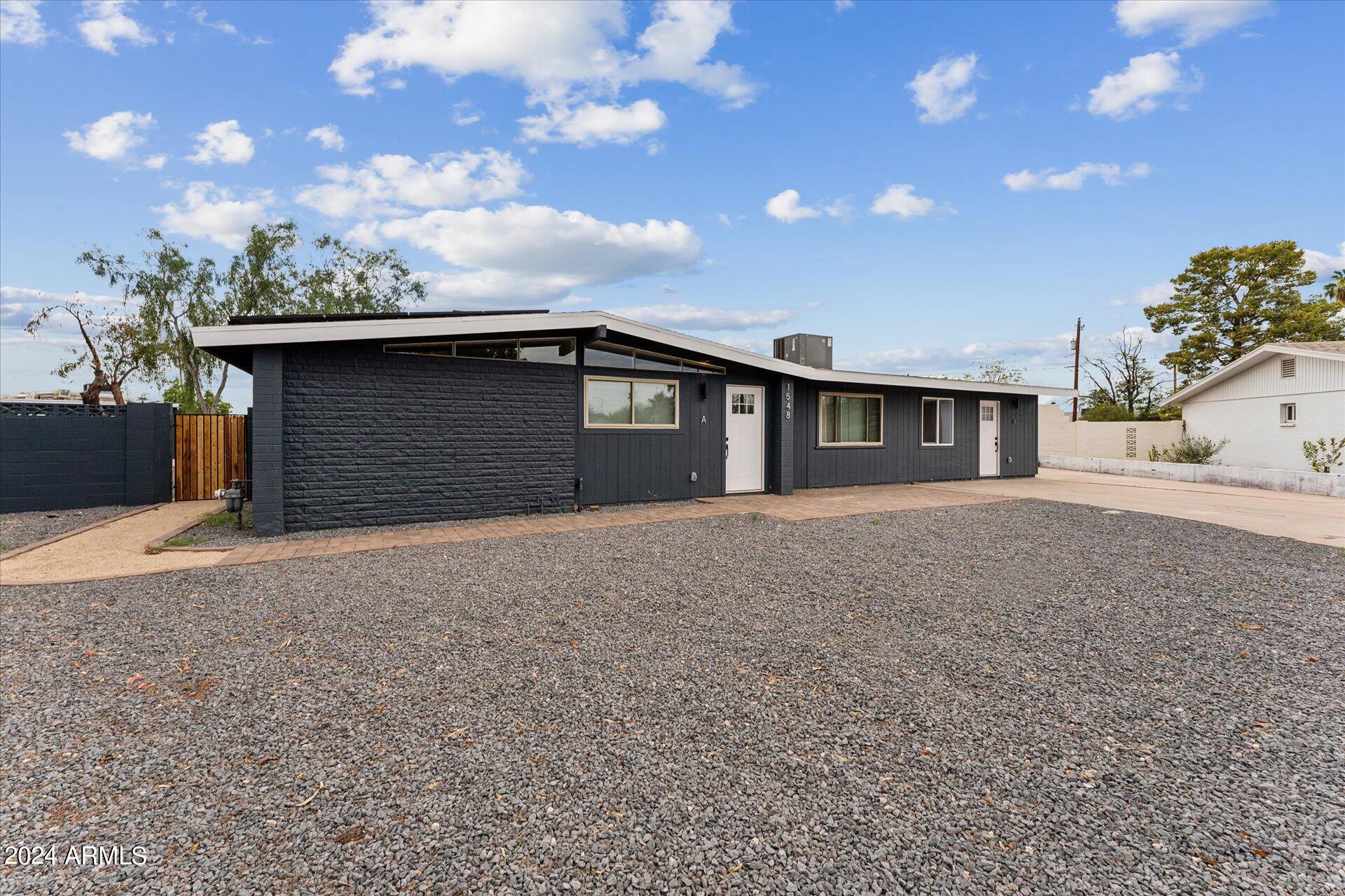 1548 North Upland Circle, Unit C Mesa, AZ 85201 - Photo 4 of 21 a front view of a house with a yard and garage