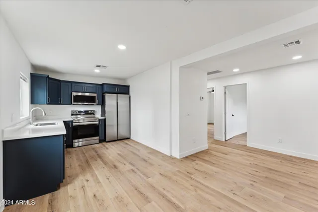 a kitchen with a refrigerator and a stove top oven