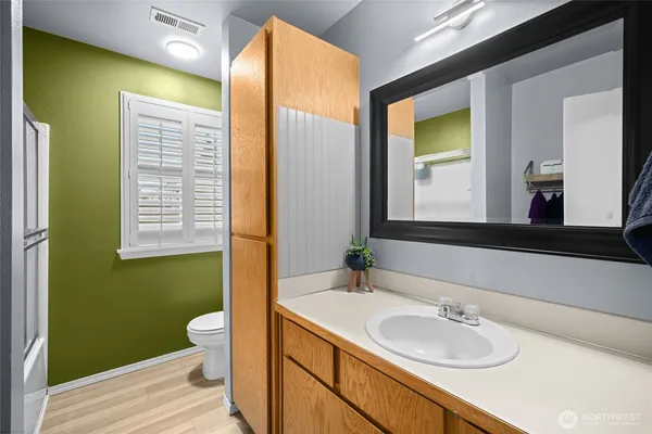 a bathroom with a sink a toilet and shower