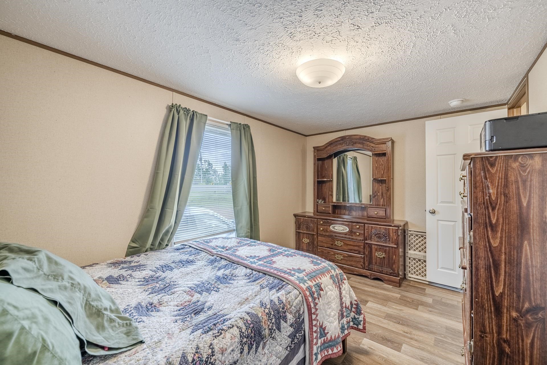 3275 Glendale Road Adamsville, TN 38310 - Photo 30 of 39 a bedroom with a bed dresser and a large window