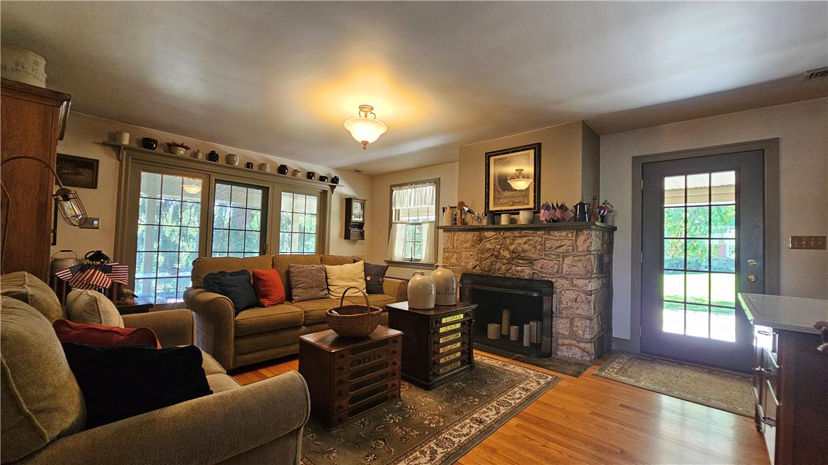 585 Buttermilk Road Hellertown, PA 18055 - Photo 5 of 82 A comforting living area boasts a rustic stone fireplace and ample natural light through large windows.