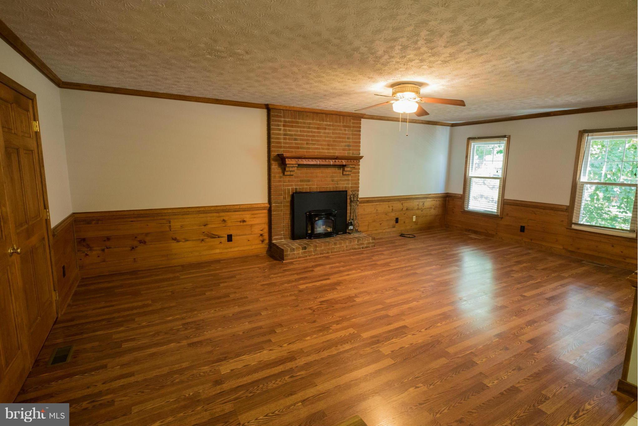 2034 Coast Guard Drive Stafford, VA 22554 - Photo 7 of 30 an empty room with wooden floor fireplace and windows