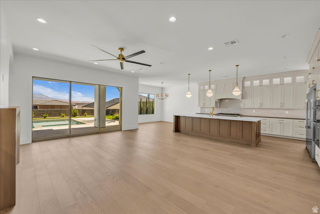 1620 Belayer Drive St. George, UT 84770 - Photo 9 of 51 Open-concept living area with wood-finish flooring, a contemporary ceiling fan, and sliding glass doors leading to a private pool