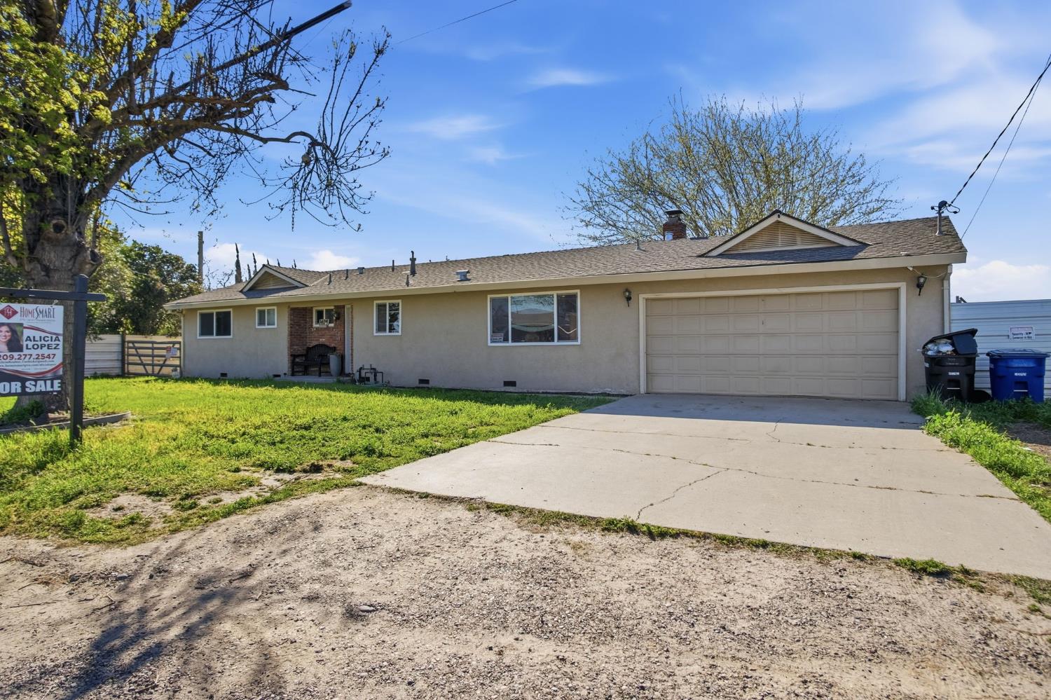 1409 Stonum Road Modesto, CA 95351 - Photo 3 of 40 a front view of a house with a garden and entryway
