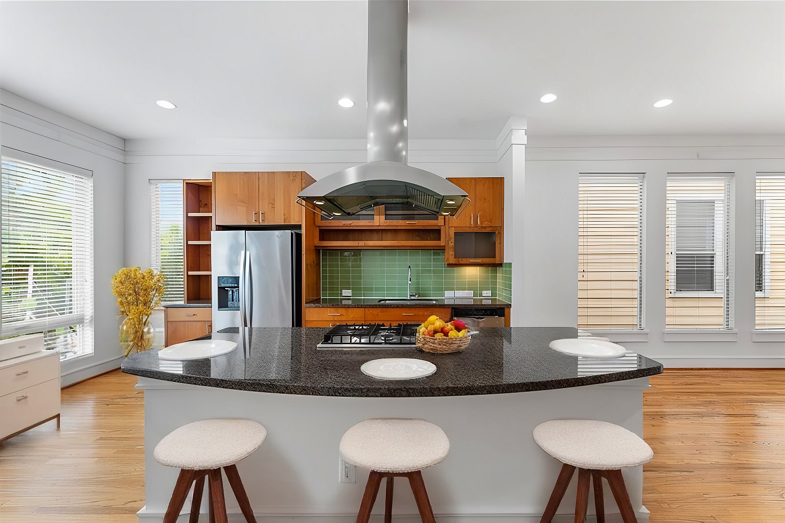 a kitchen with stainless steel appliances a dining table and chairs with wooden floor