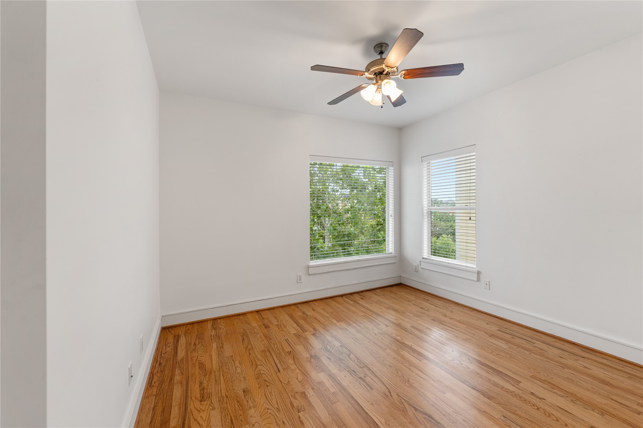 6112 Tyne Street, Unit B Houston, TX 77007 - Photo 30 of 33 an empty room with wooden floor fan and windows