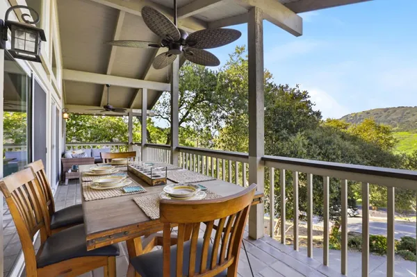a view of a balcony with wooden floor and fence