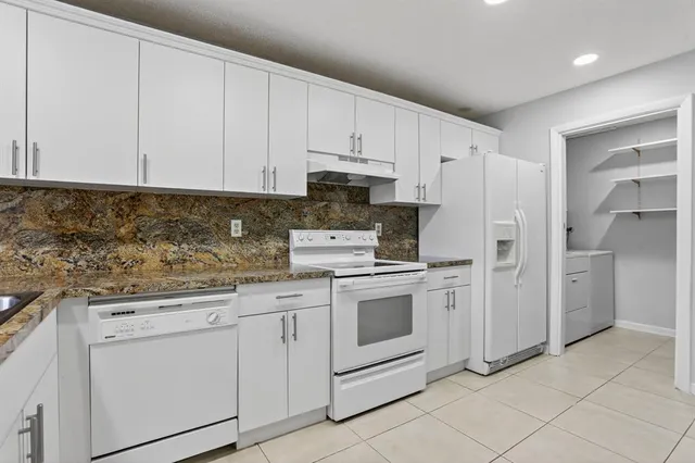 a kitchen with white cabinets and white appliances