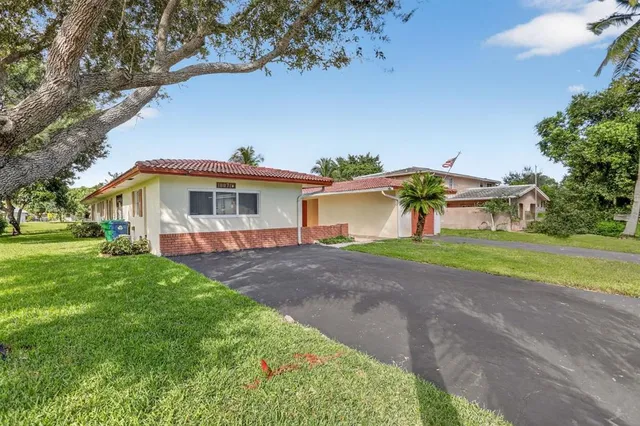 a front view of a house with yard and green space