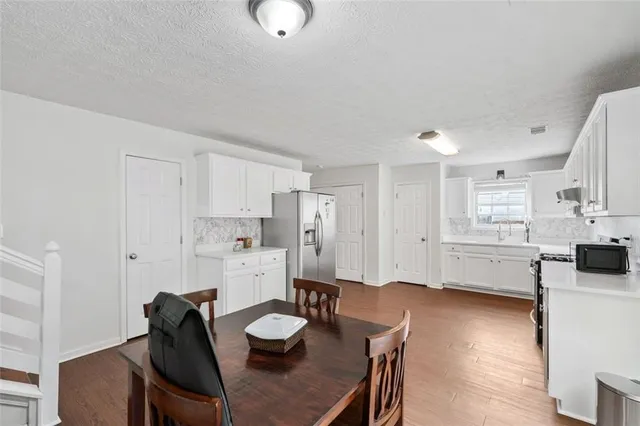 a kitchen with white cabinets and appliances