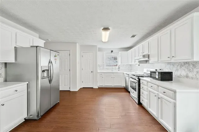 a kitchen with stainless steel appliances a refrigerator sink and cabinets