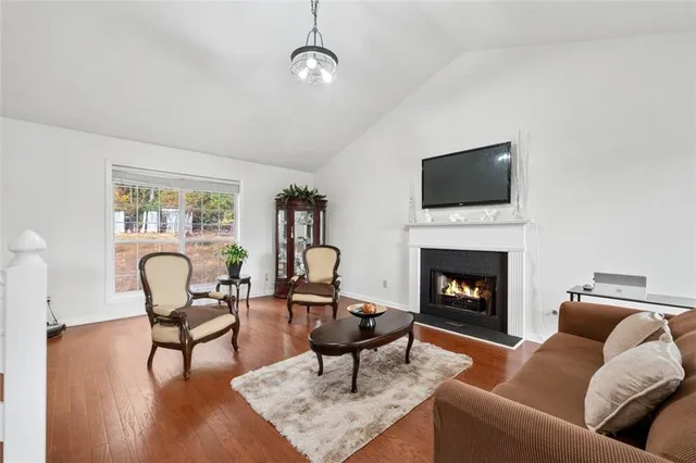 a living room with furniture a fireplace and a flat screen tv