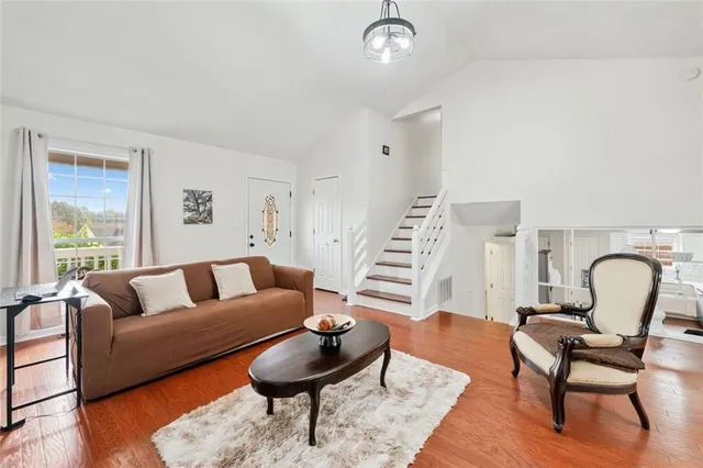 a living room with furniture and a wooden floor