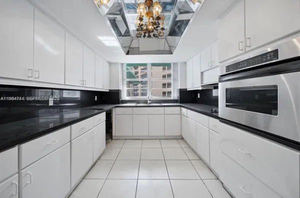 a kitchen with stainless steel appliances kitchen island granite countertop a refrigerator and a stove top oven