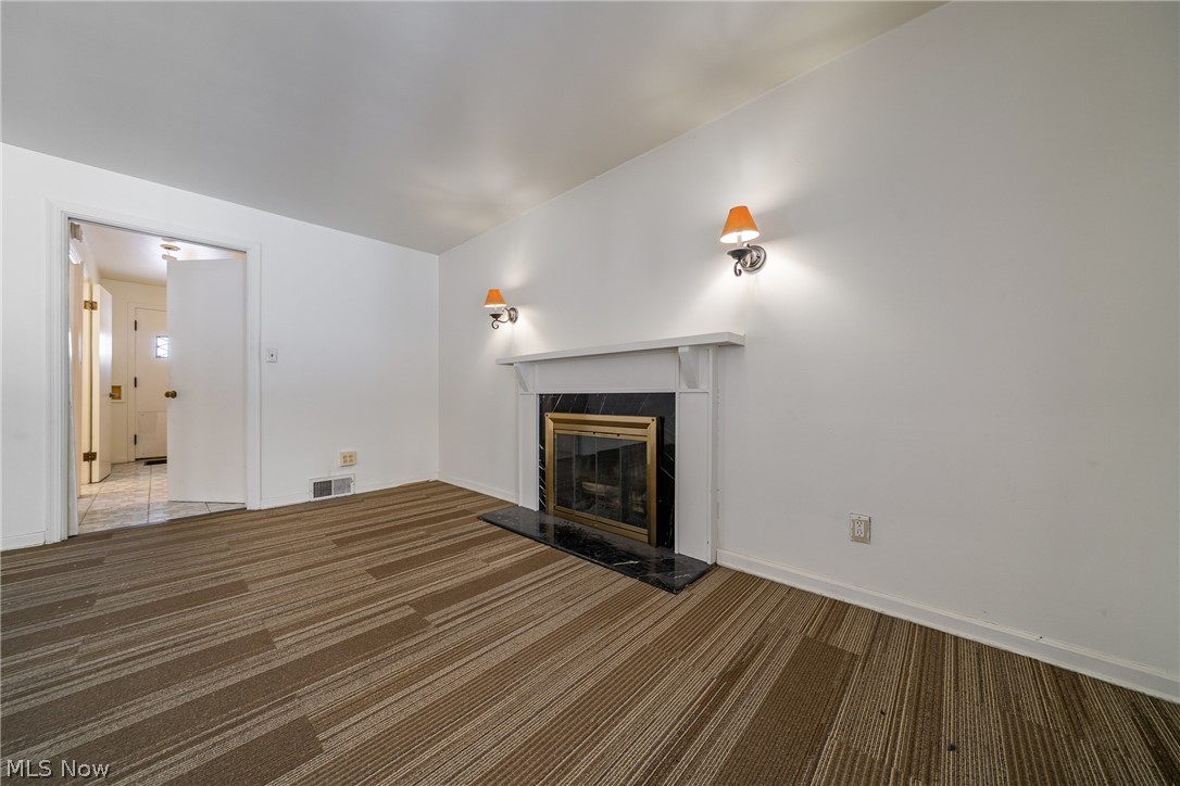 4602 College Road South Euclid, OH 44121 - Photo 4 of 26 Unfurnished living room with dark colored carpet and a fireplace