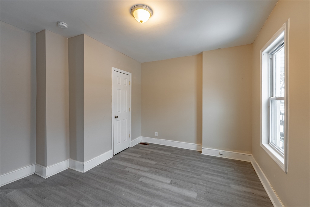 84-86 Bowles Street Springfield, MA 01109 - Photo 11 of 21 an empty room with wooden floor and windows