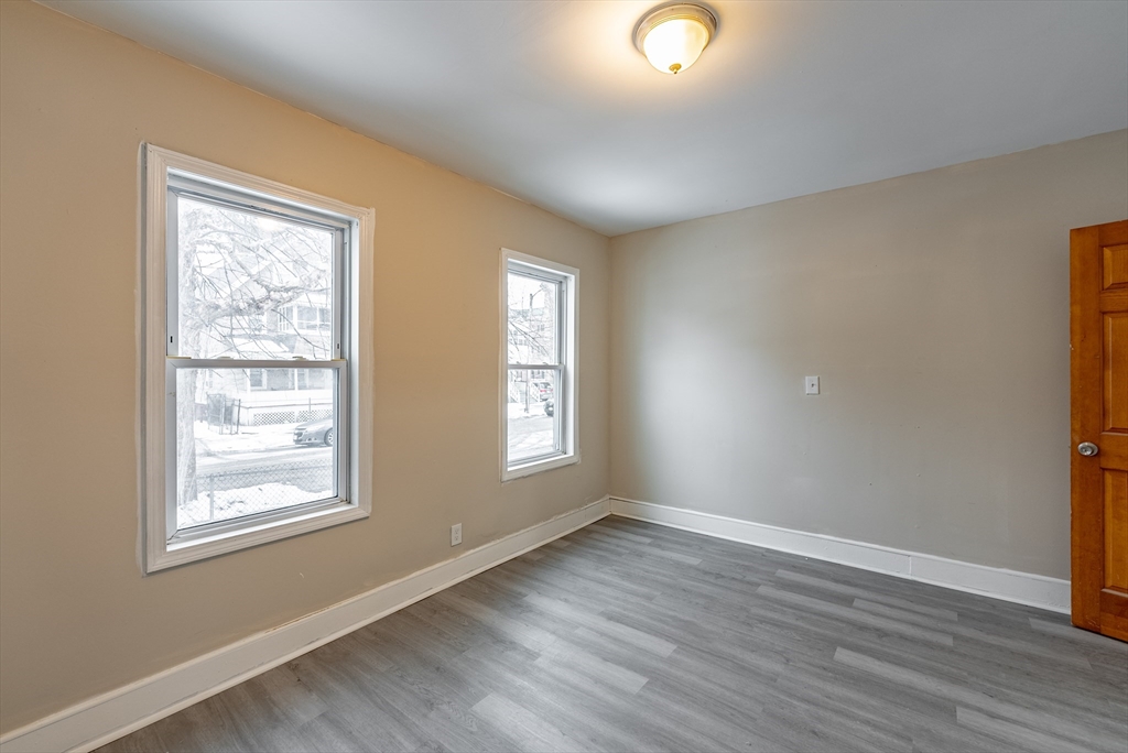 84-86 Bowles Street Springfield, MA 01109 - Photo 13 of 21 a view of an empty room with wooden floor and a window