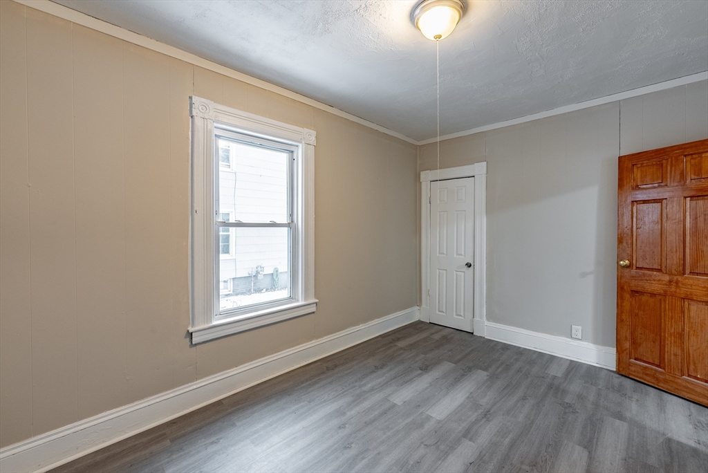 84-86 Bowles Street Springfield, MA 01109 - Photo 17 of 21 an empty room with wooden floor cabinet and windows
