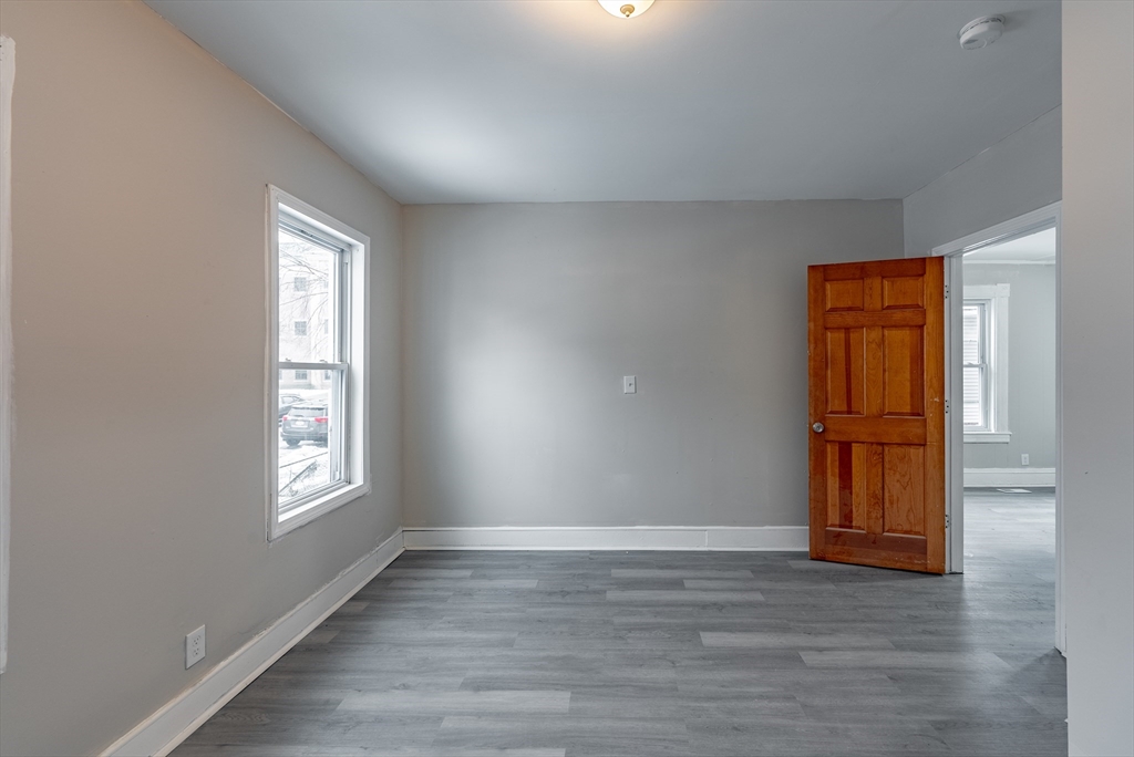 84-86 Bowles Street Springfield, MA 01109 - Photo 18 of 21 a view of an empty room with wooden floor and window