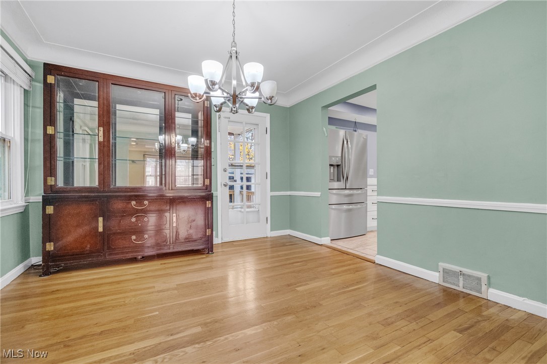 4430 Silsby Road Cleveland, OH 44118 - Photo 16 of 43 Unfurnished dining area with a notable chandelier, light hardwood / wood-style floors, and ornamental molding